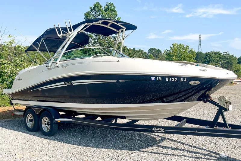 Slide: The Image of 2007 Sea Ray 260 Sundeck boat on trailer, parked outdoors, with trees in background. - 1