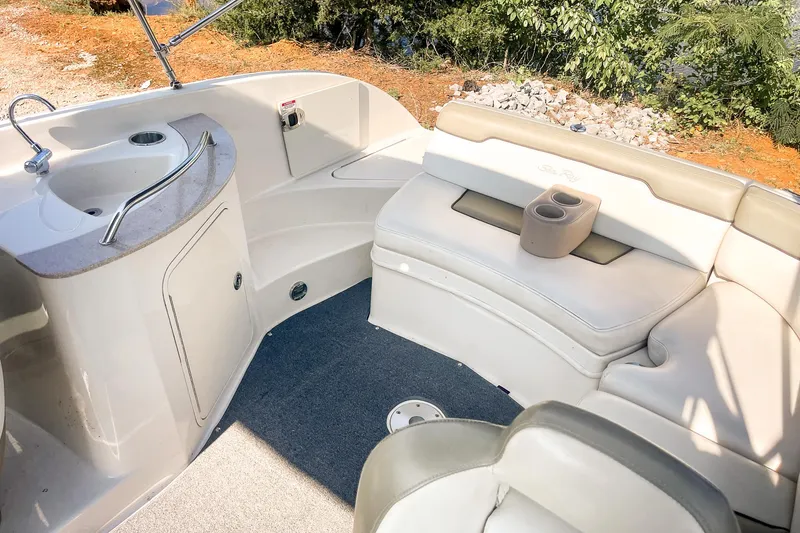 Slide: The Image of 2007 Sea Ray 260 Sundeck interior with seating and sink, featuring beige upholstery. - 22
