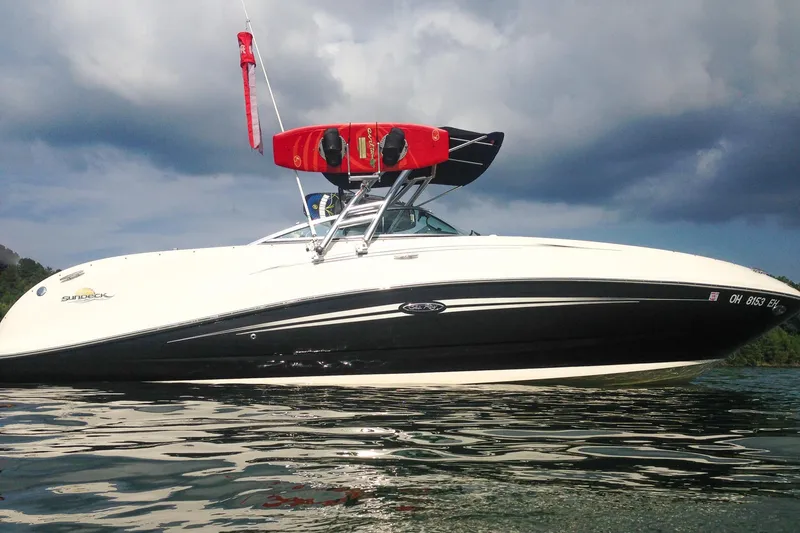 Slide: The Image of 2007 Sea Ray 260 Sundeck boat on water, under cloudy sky, with wakeboards mounted. - 24