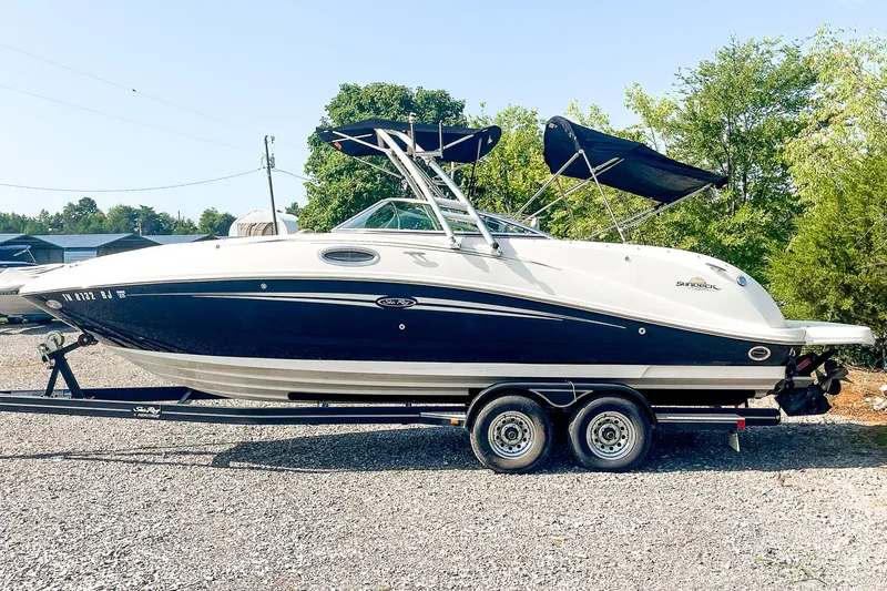 Slide: The Image of 2007 Sea Ray 260 Sundeck boat on trailer, parked outdoors with trees in background. - 5