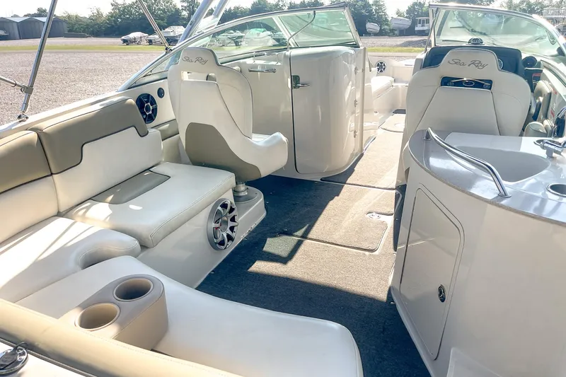Slide: The Image of Interior of a 2007 Sea Ray 260 Sundeck boat with white seating and modern amenities. - 9