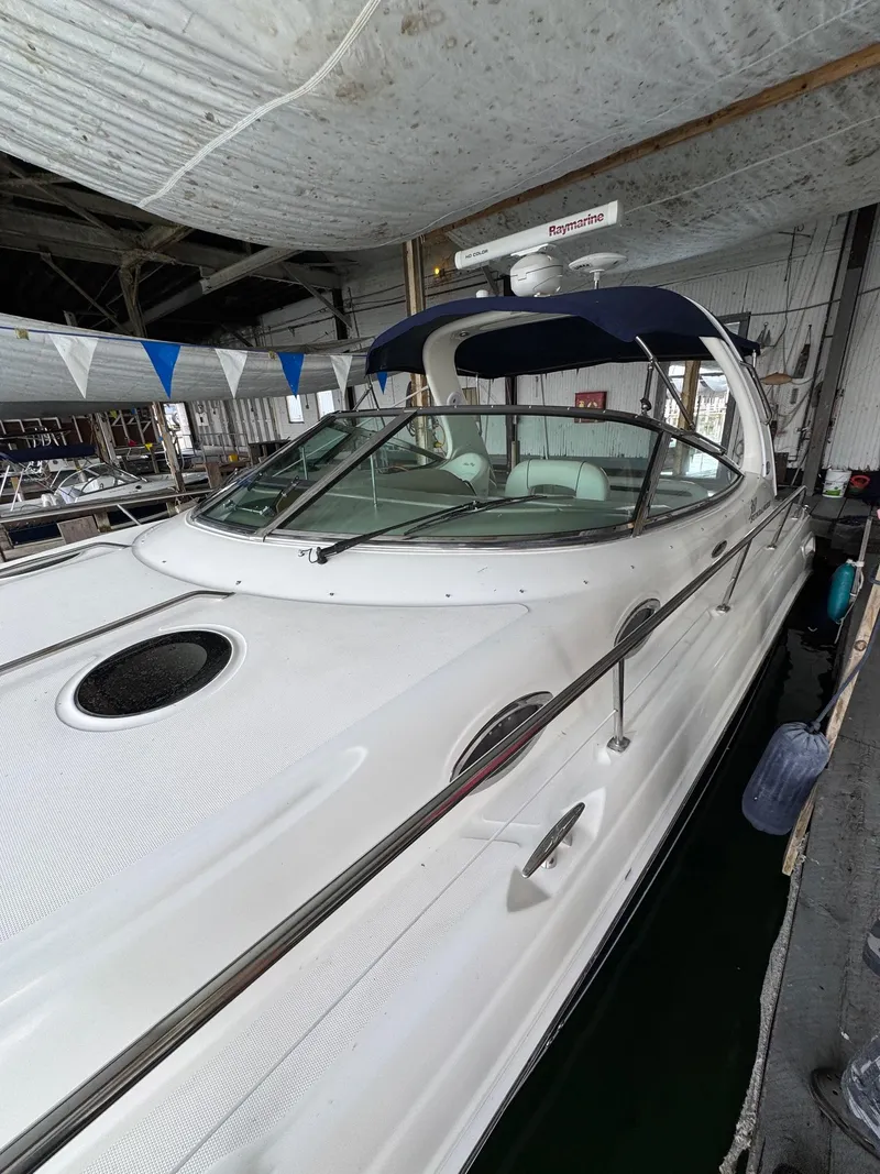 The Image of 2010 Sea Ray 360DA yacht docked in a marina, featuring sleek design and blue canopy. - 0