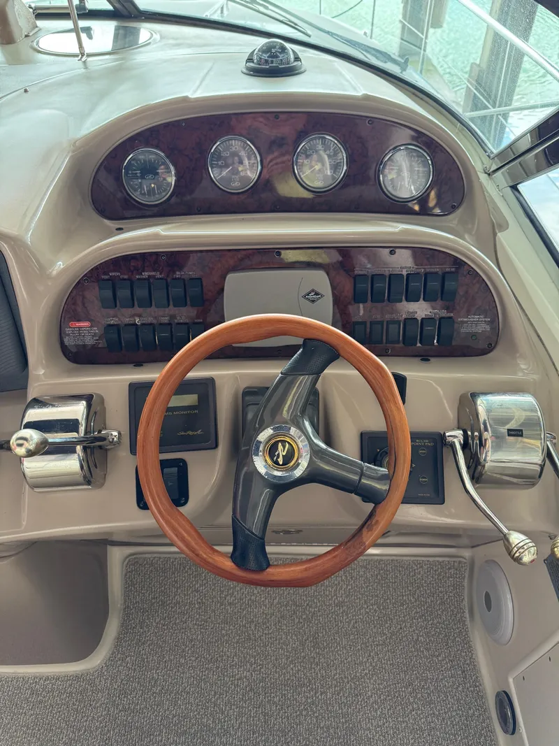 Slide: The Image of Steering console of 2010 Sea Ray 360DA boat with wooden wheel and control panel. - 22