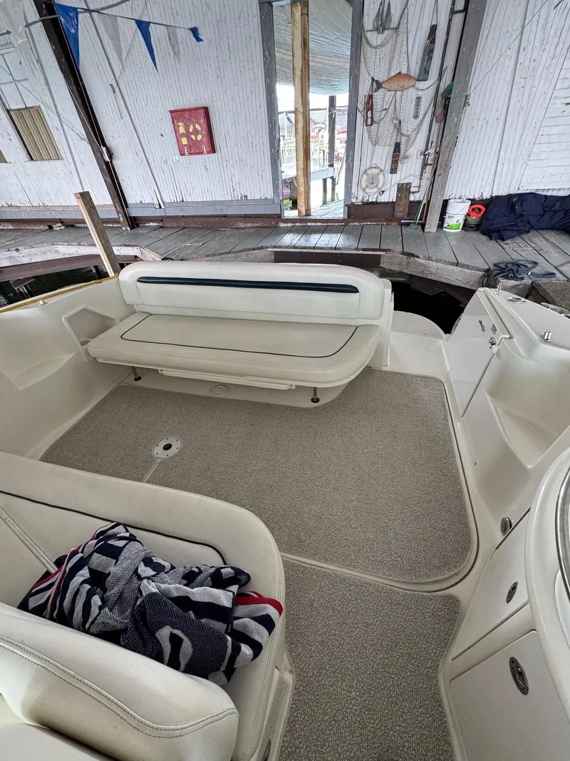 Slide: The Image of Interior view of a 2010 Sea Ray 360DA boat with seating and dockside background. - 6