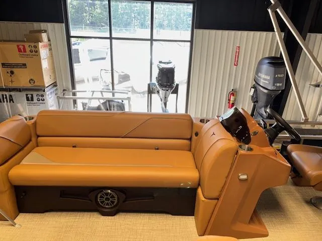 Slide: The Image of 2025 Tahoe Pontoon SP 2180 CR interior with tan seating and Yamaha engine in showroom. - 13