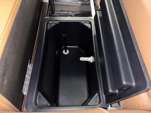 Slide: The Image of 2025 Tahoe Pontoon SP 2180 CR storage compartment with black interior and tan seating. - 31