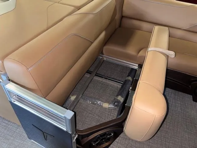Slide: The Image of 2025 Tahoe Pontoon SP 2180 CR interior seating with tan upholstery and storage compartment. - 32
