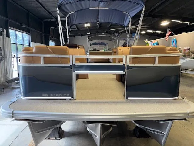 Slide: The Image of 2025 Tahoe Pontoon SP 2180 CR in showroom, featuring tan seating and blue exterior. - 4