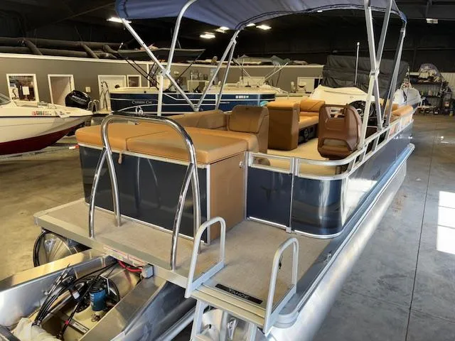 Slide: The Image of 2025 Tahoe Pontoon SP 2180 CR in showroom, featuring tan seating and canopy. - 9