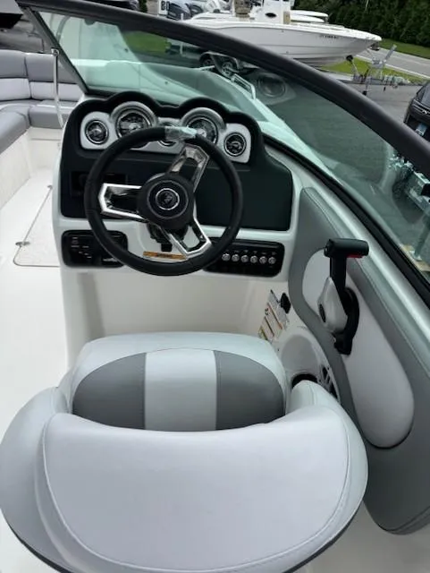 Slide: The Image of 2023 NauticStar 243 DC boat cockpit with steering wheel and dashboard controls. - 6