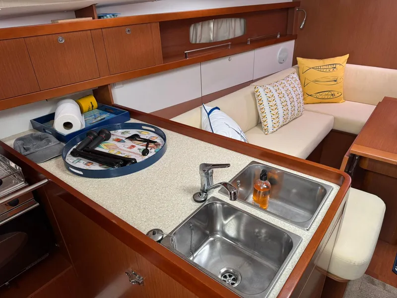 Slide: The Image of Interior of 2014 Beneteau 37 yacht, featuring a cozy galleyand seating area. - 18
