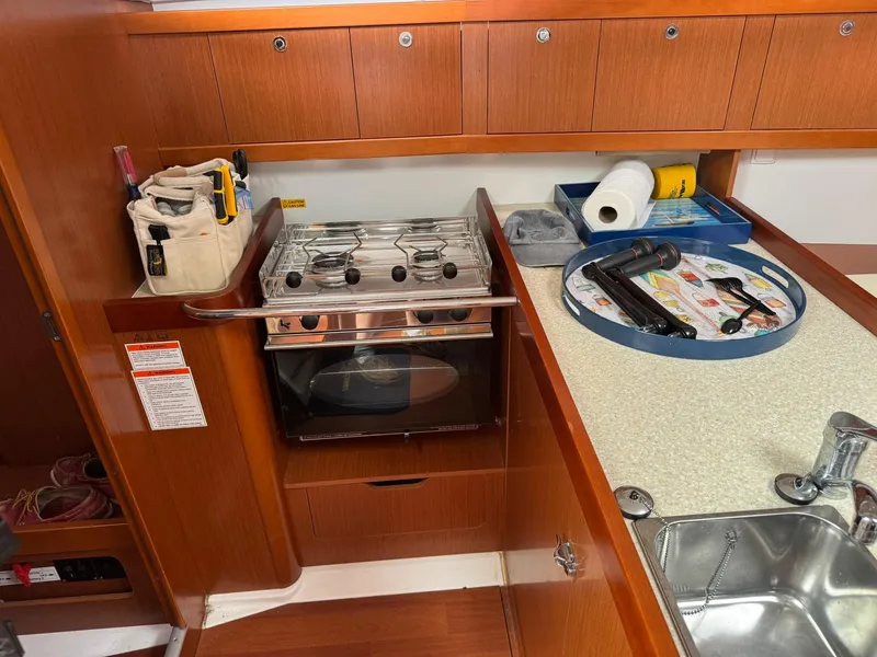 Slide: The Image of Galley in 2014 Beneteau 37 sailboat with stove, sink, and storage. - 19