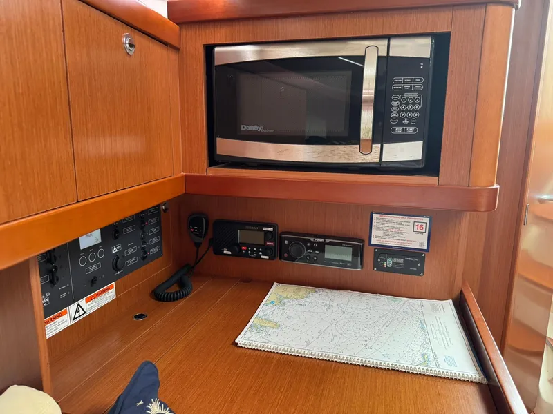 Slide: The Image of Interior of 2014 Beneteau 37 yacht with microwave, navigation equipment, and map. - 21