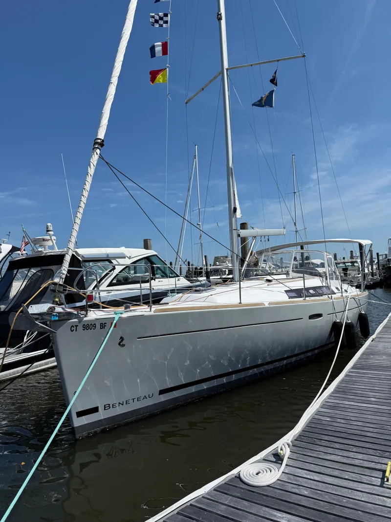 Slide: The Image of 2014 Beneteau 37 sailboat docked at marina with flags on mast. - 28