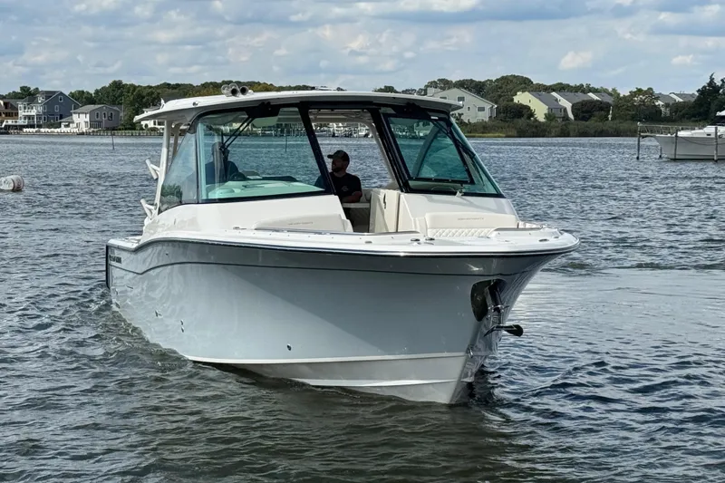 Slide: The Image of 2026 Grady-White Freedom 345 boat cruising on a calm lake with houses in the background. - 12