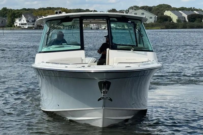 Slide: The Image of 2026 Grady-White Freedom 345 boat cruising on a calm lake near residential area. - 13