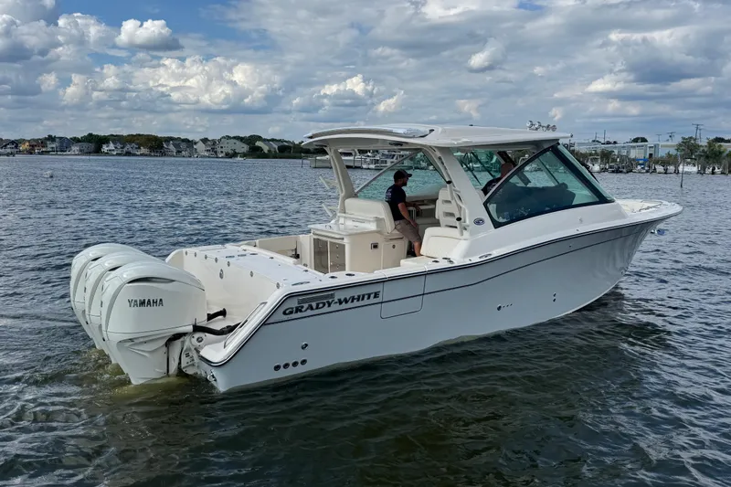 Slide: The Image of 2026 Grady-White Freedom 345 boat on water, featuring Yamaha engines, under a cloudy sky. - 26
