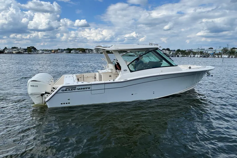 Slide: The Image of 2026 Grady-White Freedom 345 boat on water, featuring Yamaha engines, under a cloudy sky. - 27