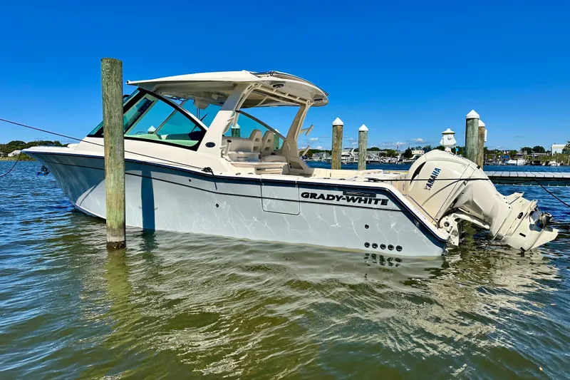 Slide: The Image of 2026 Grady-White Freedom 345 boat docked in calm waters under clear blue sky. - 31