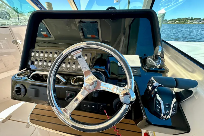 Slide: The Image of Helm of 2026 Grady-White Freedom 345 boat with steering wheel and controls. - 42