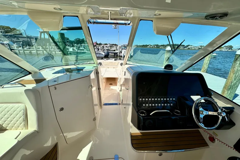 Slide: The Image of 2026 Grady-White Freedom 345 boat interior with helm, docked by the water. - 44