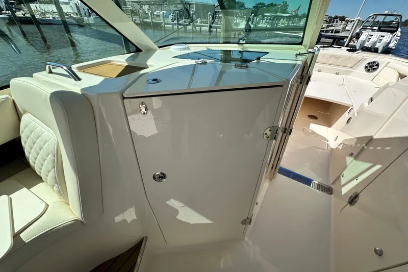 Slide: The Image of 2026 Grady-White Freedom 345 boat interior with seating and storage, docked at marina. - 45