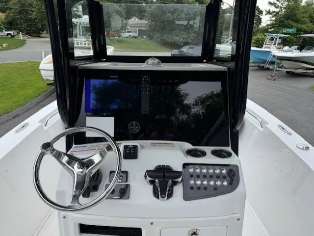 Slide: The Image of 2024 NauticStar 252 Legacy boat dashboard with steering wheel and control panel. - 2