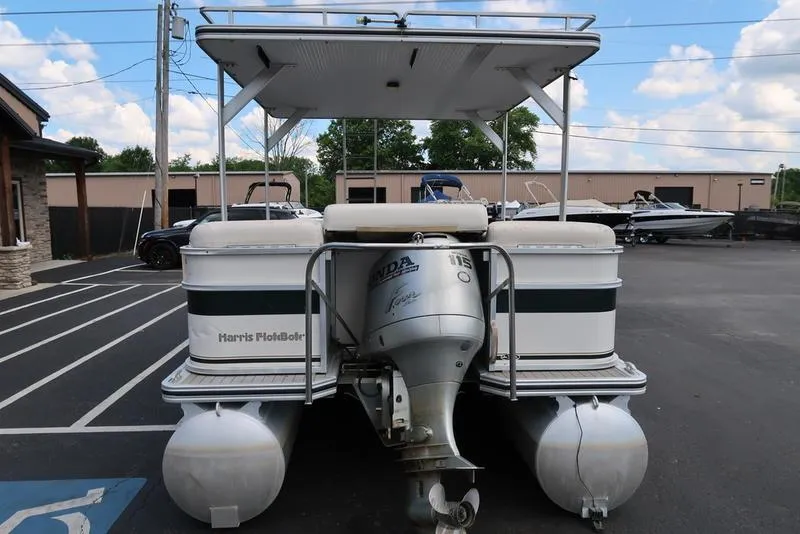 Slide: The Image of 2001 Harris Super Sunliner 240 pontoon boat with Honda outboard motor in parking lot. - 14