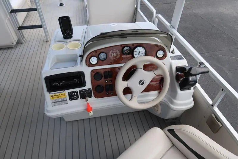 Slide: The Image of 2001 Harris Super Sunliner 240 boat dashboard with steering wheel and control panel. - 15