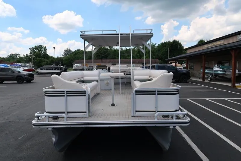 Slide: The Image of 2001 Harris Super Sunliner 240 pontoon boat with white seating, parked in a lot. - 4
