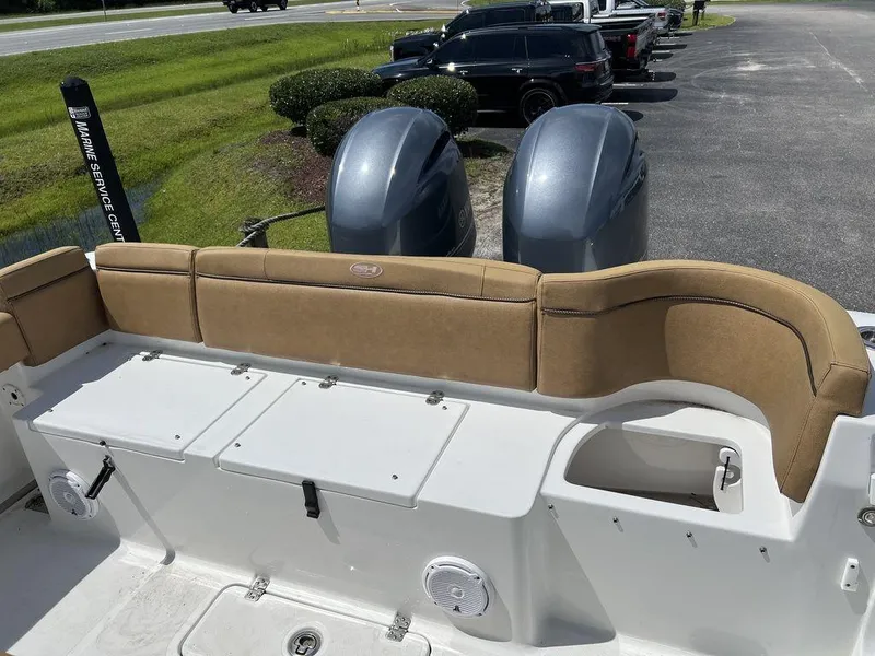 Slide: The Image of 2020 Sea Hunt Ultra 275 SE boat with tan seating and dual engines in a parking lot. - 15