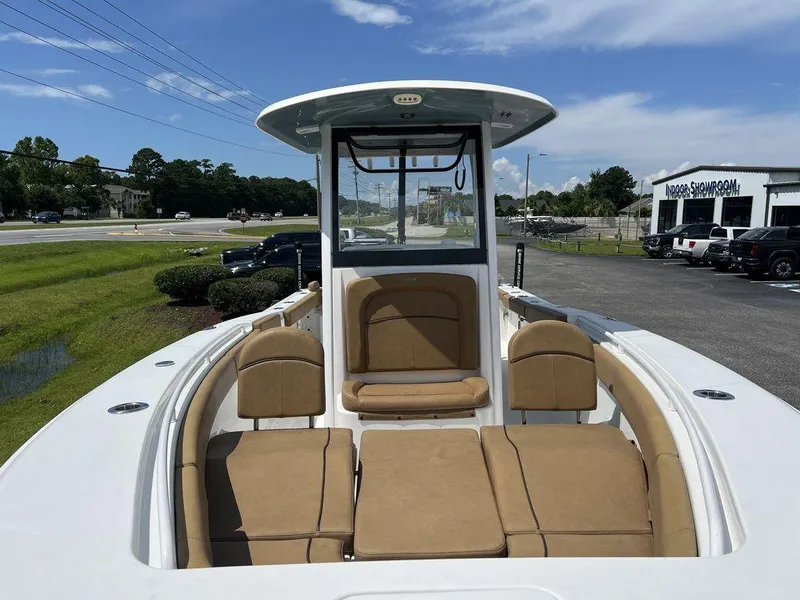 Slide: The Image of 2020 Sea Hunt Ultra 275 SE boat with tan seating, parked outdoors near showroom. - 7