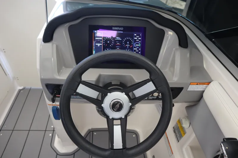 Slide: The Image of 2023 Chaparral 23 Surf boat dashboard with steering wheel and digital display. - 14