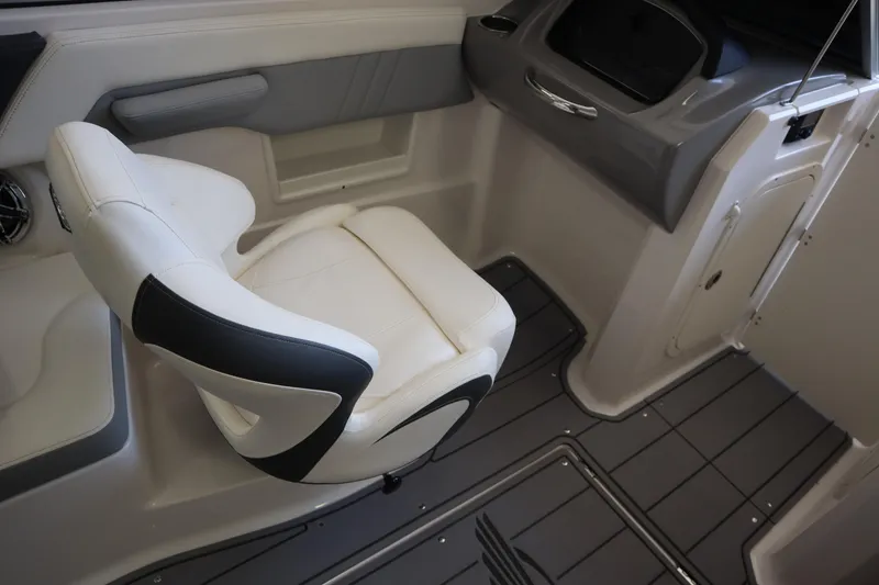 Slide: The Image of 2023 Chaparral 23 Surf boat interior with white and black seating, gray flooring. - 19