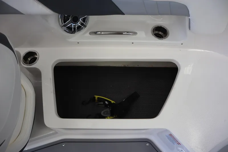 Slide: The Image of 2023 Chaparral 23 Surf boat storage compartment with cup holders and speaker. - 23