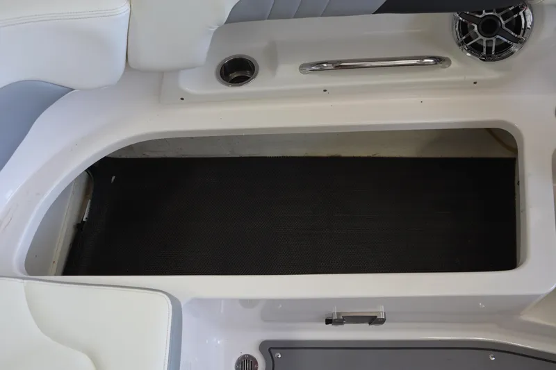 Slide: The Image of 2023 Chaparral 23 Surf boat interior storage compartment with cup holder and speaker. - 27