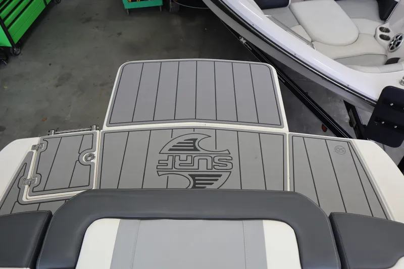 Slide: The Image of 2023 Chaparral 23 Surf boat deck with gray padding and logo. - 29