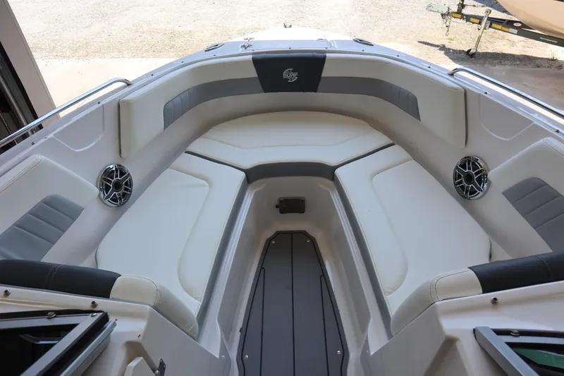 Slide: The Image of 2023 Chaparral 23 Surf boat interior with cushioned seating and speakers. - 6