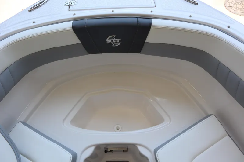 Slide: The Image of 2023 Chaparral 23 Surf boat interior with cushioned seating and storage area. - 8