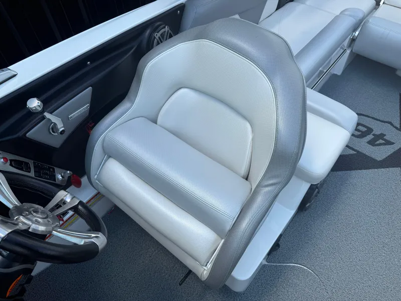 Slide: The Image of 2016 MasterCraft X46 boat interior with gray and white seating and steering wheel. - 14