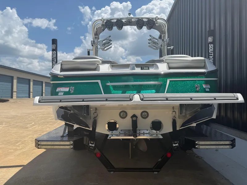 Slide: The Image of 2016 MasterCraft X46 boat with green hull, parked outdoors under a cloudy sky. - 3