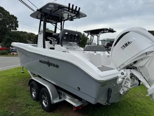 Slide: The Image of 2025 NauticStar 242 Offshore boat on trailer with Yamaha engine, parked on grass. - 3