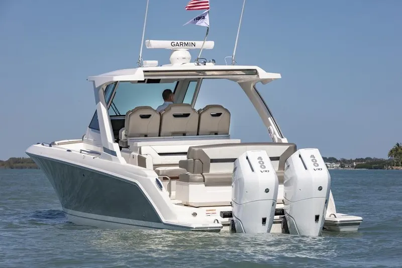 Slide: The Image of 2026 Tiara Yachts 34 LS luxury seating with cup holder, docked under clear blue sky. - 5