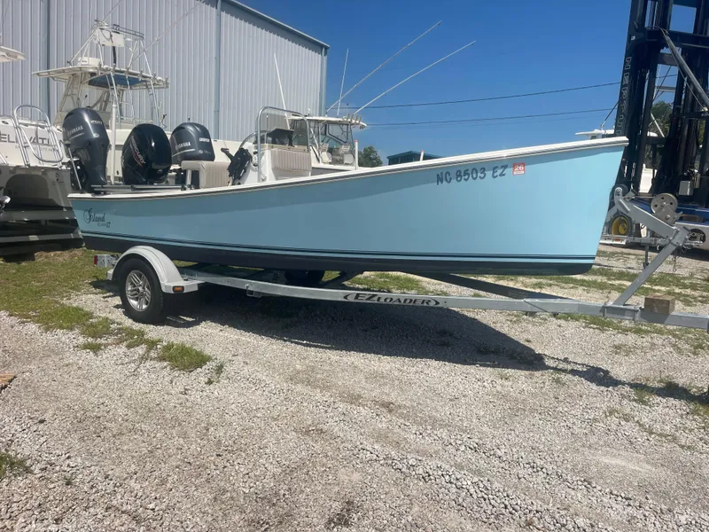 Slide: The Image of 2023 Intruder ISLAND CLASSIC 17 boat on trailer, light blue hull, parked outdoors. - 3