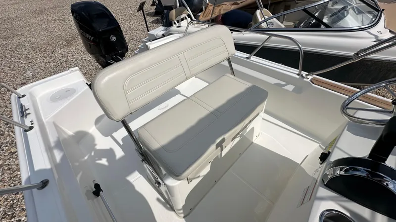 Slide: The Image of 2022 Boston Whaler 150 Montauk boat interior with seating and Mercury engine. - 10