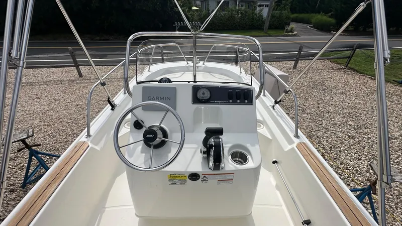 Slide: The Image of 2022 Boston Whaler 150 Montauk boat interior with steering wheel and Garmin navigation system. - 11