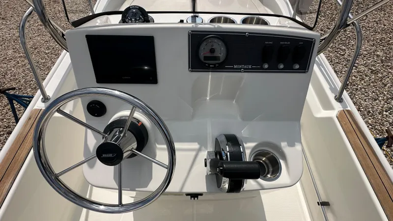 Slide: The Image of 2022 Boston Whaler 150 Montauk boat console with steering wheel and controls. - 12