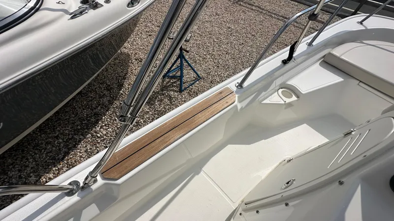 Slide: The Image of 2022 Boston Whaler 150 Montauk interior with stainless steel railings and wooden accents. - 13
