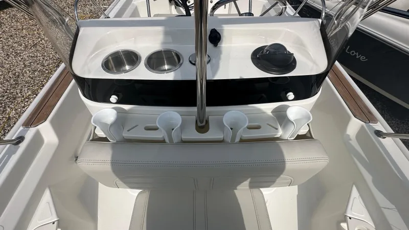 Slide: The Image of 2022 Boston Whaler 150 Montauk boat console with cup holders and steering wheel. - 19