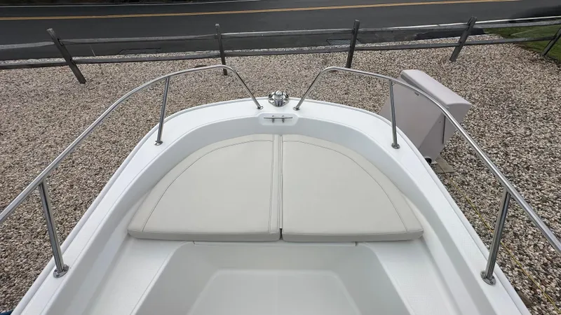 Slide: The Image of 2022 Boston Whaler 150 Montauk boat bow with cushioned seating and stainless steel railings. - 20